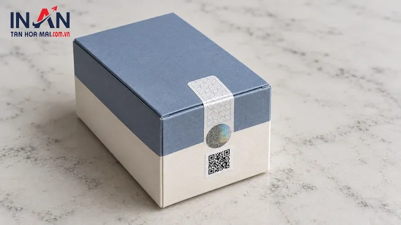 Hộp quà xanh trắng có tem niêm phong và mã QR ở mặt trước